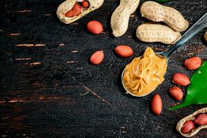 A spoonful of peanut butter on a table with leaves. photo