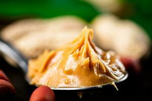 Spoon with peanut butter. Macro background. photo