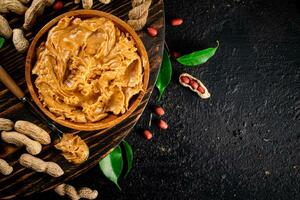 Peanut butter on a wooden tray with leaves. photo