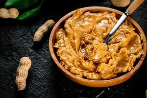 Peanut butter in a wooden plate. photo