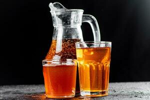 Apple juice in a jug and glasses with air bubbles. photo