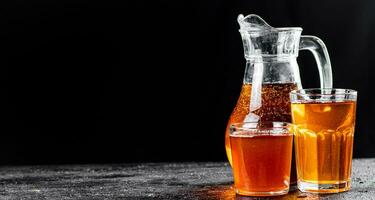 Apple juice in a jug and glasses with air bubbles. photo