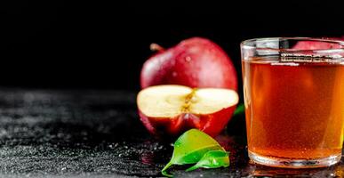 A full glass of apple juice with leaves. photo