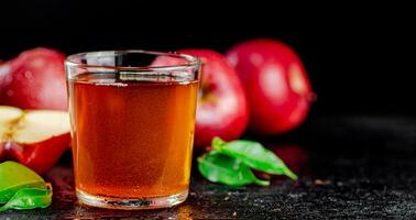 un lleno vaso de manzana jugo con hojas. foto