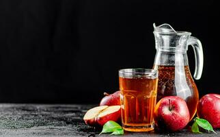 manzana jugo en un jarra y un vaso en el mesa. foto