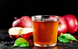 un lleno vaso de manzana jugo con hojas. foto