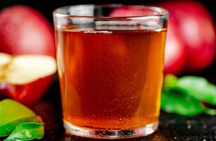 un lleno vaso de manzana jugo con hojas. foto