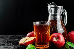 Apple juice in a jug and a glass on the table. photo