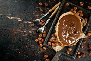 Hazelnut butter in a plate on a cutting board with paper. photo