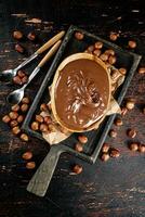 Hazelnut butter in a plate on a cutting board with paper. photo