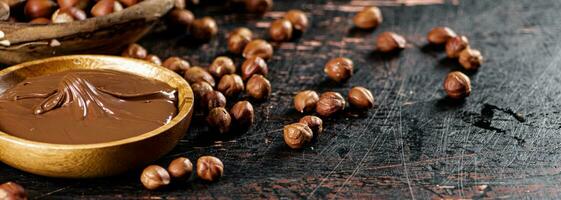 Hazelnut butter with peeled hazelnuts on the table. photo