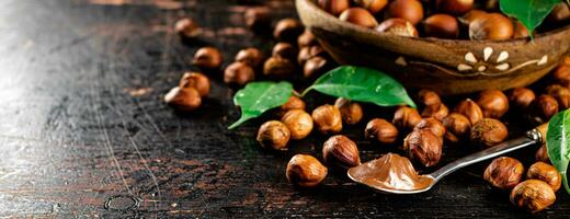 Hazelnut butter in a spoon on a table with leaves. photo