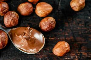 Hazelnut butter in a spoon on the table. photo