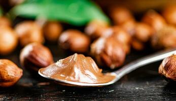 Hazelnut butter in a spoon on the table. photo