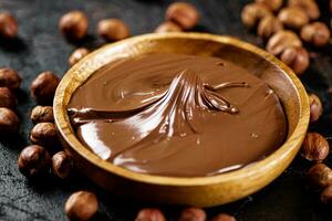 Hazelnut butter with peeled hazelnuts on the table. photo