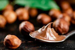 Hazelnut butter in a spoon on the table. photo