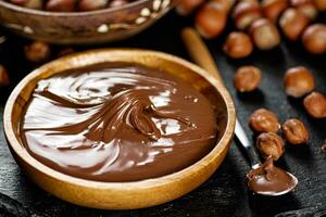 Hazelnut butter on a stone board on a plate and in a spoon. photo