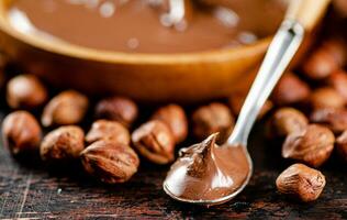 Hazelnut butter in a spoon on the table. photo