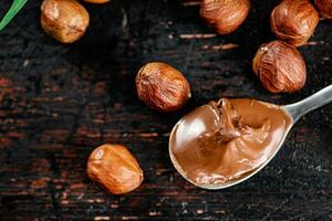 Hazelnut butter in a spoon on the table. photo