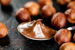 Hazelnut butter in a spoon on the table. photo