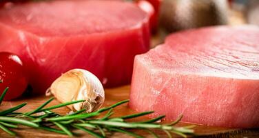Fresh raw tuna steak with rosemary and garlic. photo