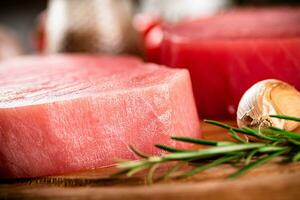 Fresh raw tuna steak with rosemary and garlic. photo