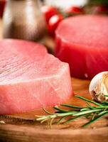 Fresh raw tuna steak with rosemary and garlic. photo