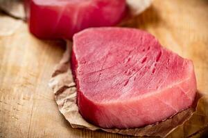 Fresh raw tuna steak on the table. photo