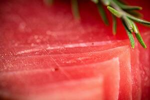 Raw tuna with a sprig of rosemary. photo