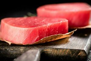 Raw tuna steak on a cutting board. photo