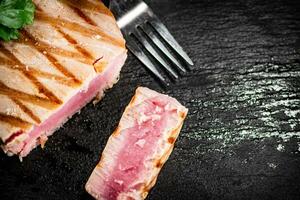 A piece of grilled tuna with parsley. photo