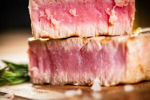 A piece of grilled tuna on a cutting board. photo