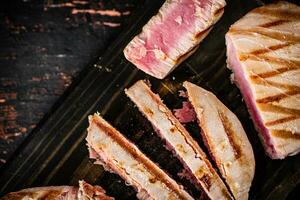 Grilled tuna on a cutting board. photo