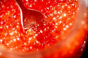 Red caviar with a spoon. photo