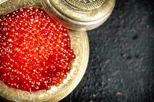 Full bowl of red caviar on the table. photo