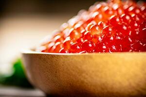 Red caviar in a plate on the table with parsley. photo