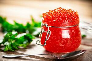 rojo caviar en un vaso tarro con perejil. foto