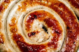 Grilled sausage with crust. Macro background. photo