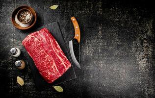 Raw beef on a stone board with a knife. photo