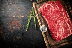 A piece of fresh raw beef on a cutting board. photo