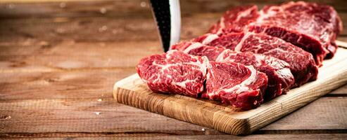 crudo carne de vaca en un corte tablero con un cuchillo. foto