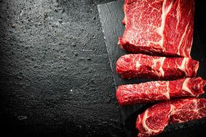 Pieces of raw beef on a stone board. photo