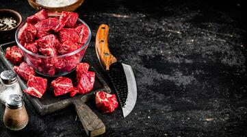 Raw beef tenderloin in a glass bowl with spices. photo