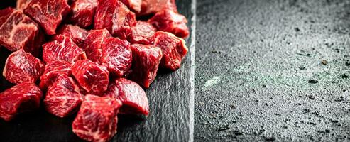 Pieces of raw beef on a stone board. photo