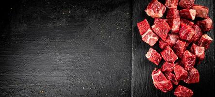 Pieces of raw beef on a stone board. photo