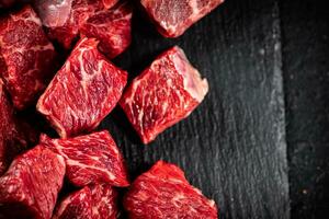 Pieces of raw beef on a stone board. photo