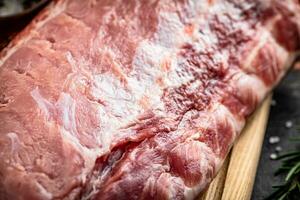 A fresh piece of raw pork on a cutting board. photo