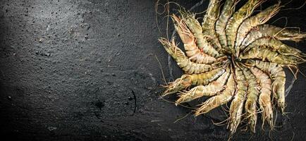 Fresh raw shrimp on a round stone board. photo