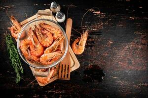 Boiled shrimp in a colander with a sprig of rosemary. photo