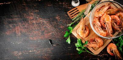 Boiled shrimp in a colander on a cutting board with parsley. photo